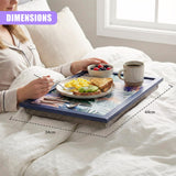 A woman in bed, holding a tray with a breakfast meal, including toast, eggs, and fruit, on a colorful, tropical-patterned tray with a blue frame, on a white bed with a white comforter. - UKBuyZone