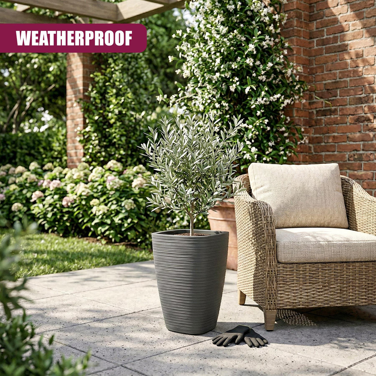 A gray, ribbed, tall flower pot holds a small green plant resting on an outdoor patio.