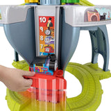 Hand attaches a blue train engine to a yellow table featuring numbered slot games.