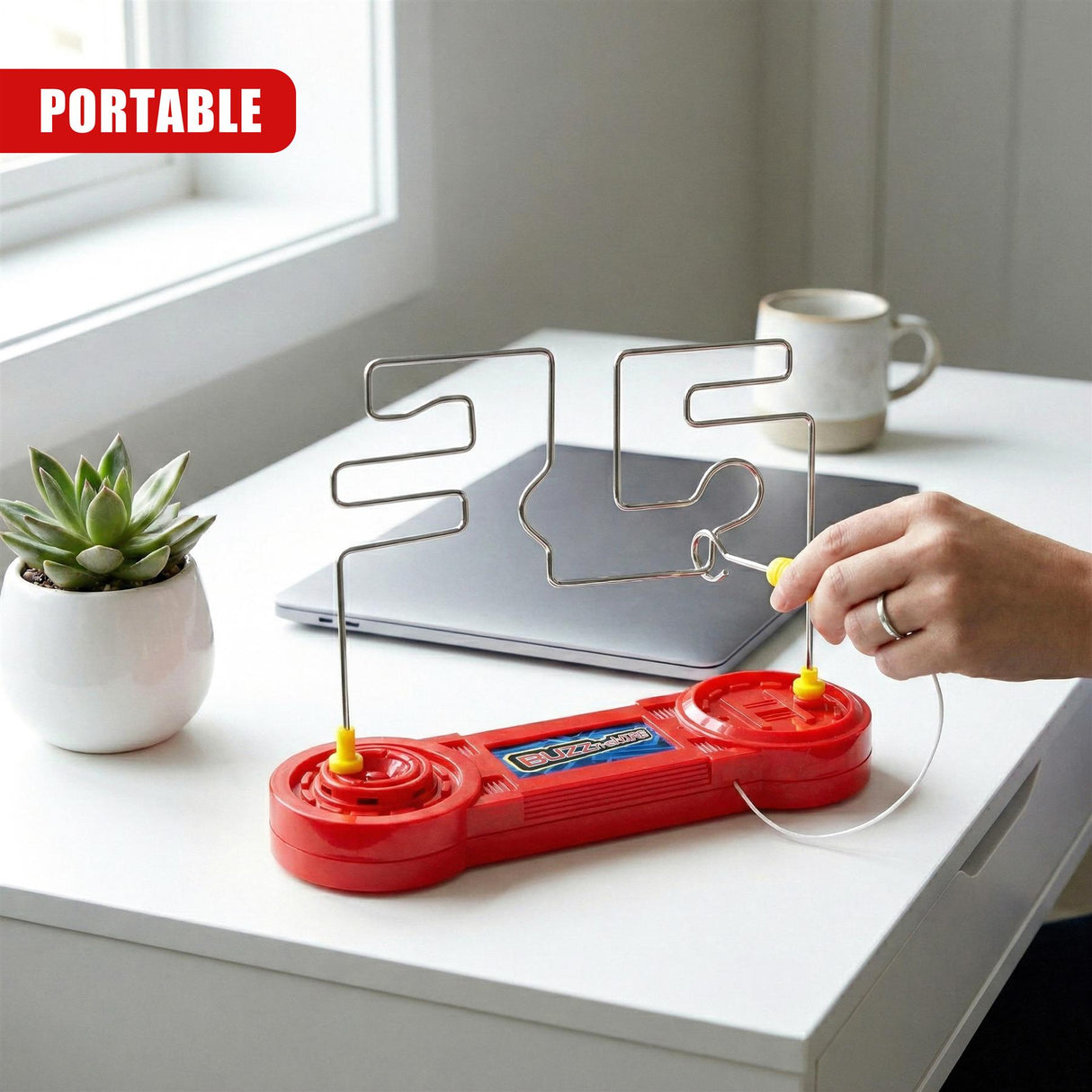 A red handheld electronic game console with metal wire obstacles for gameplay.