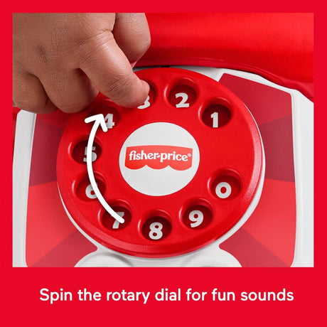 A hand is shown turning the numbered, red and white rotary dial of a toy telephone.