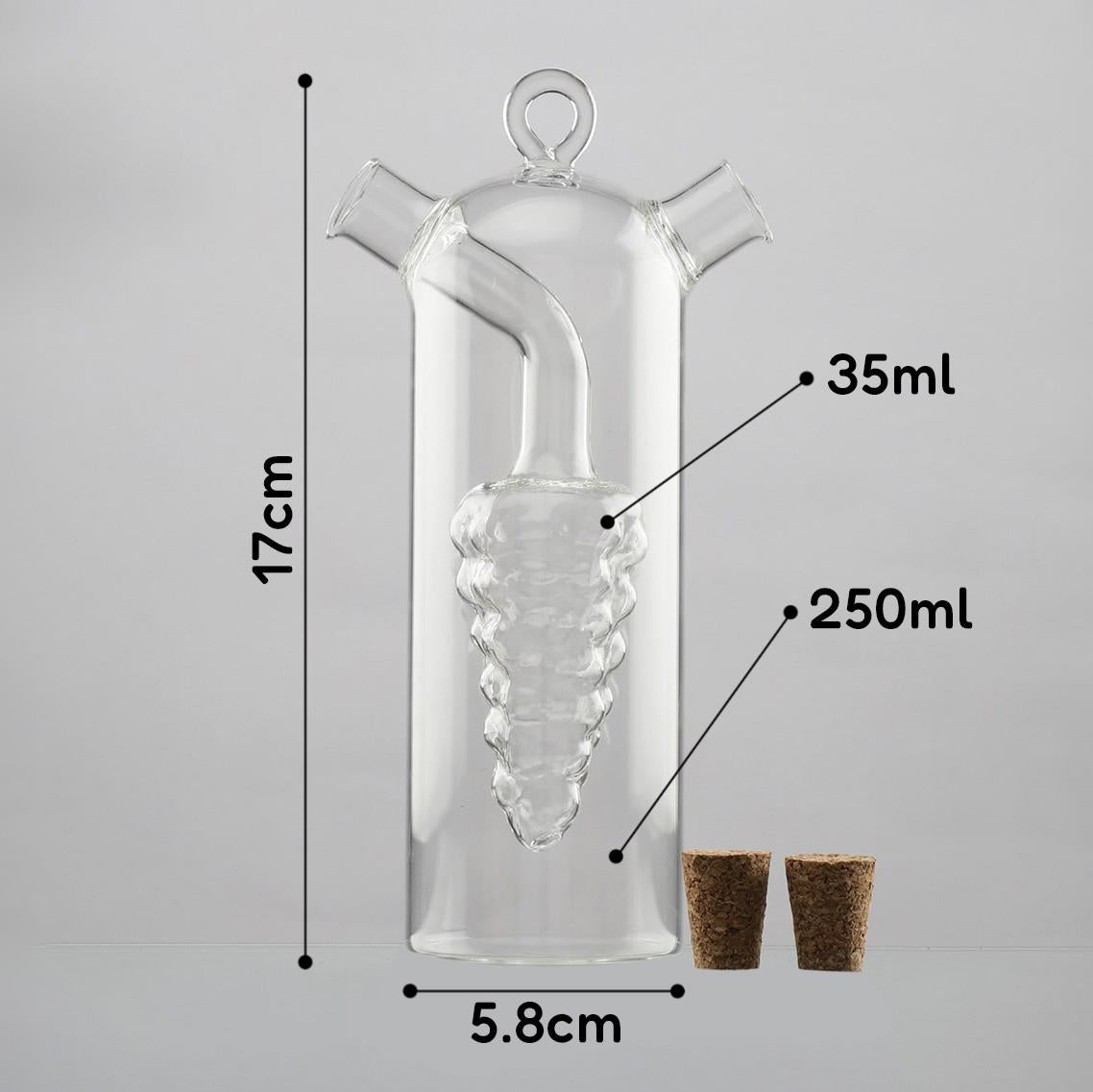 Clear glass 2-in-1 oil and vinegar dispenser with a unique design, measuring 17 cm in height and 5.8 cm in width, featuring a cork stopper. It has a capacity of 250 ml for oil or vinegar and a 35 ml capacity for pouring. Ideal for stylish kitchen storage or serving, perfect for home chefs. Available at ukbuyzone.