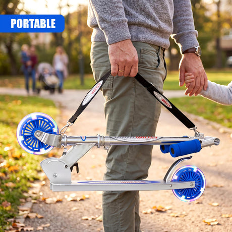 The adult holds a portable silver scooter featuring blue plastic wheels on a path.