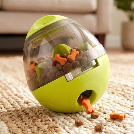 A neon green, dome-shaped dog toy filled with treats and kibble resting on a textured rug.