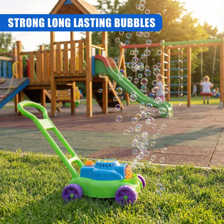 A green and blue bubble machine sits on grass, surrounded by floating soap bubbles near a playground.