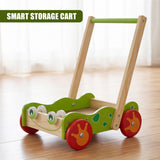 Green and natural wood baby walker toy with large wheels, standing on a polished hardwood floor.