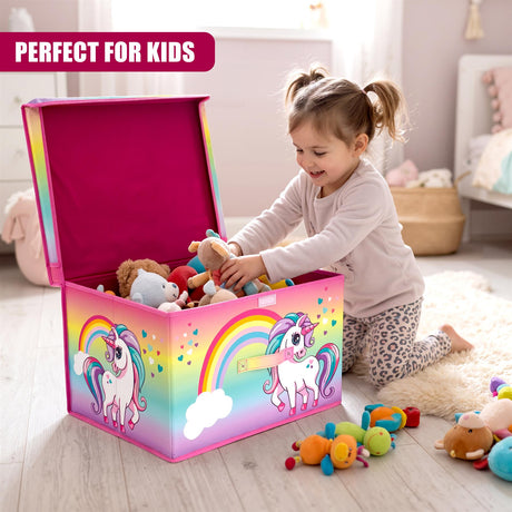 A smiling young girl with pigtails kneels on a rug, reaching into a pink Rainbow Unicorn Storage Box filled with toys