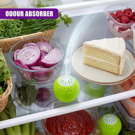 Three perforated green deodoriser balls are displayed among various fresh refrigerated foods.