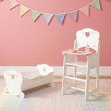 White wooden cradle and high chair set displayed against a solid pink background wall.