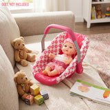 Pink car seat designed for a doll, visible on a white knitted blanket with teddy bears.