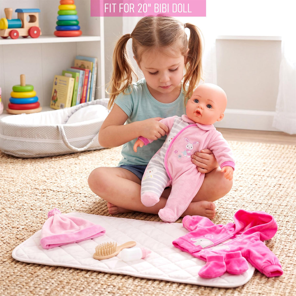 A set of pink and white doll clothes including a hat, outfit, pants, brush, and cloth accessory.