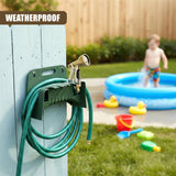 A dark green hose holder is mounted on a wooden fence post, supporting a coiled green garden hose.