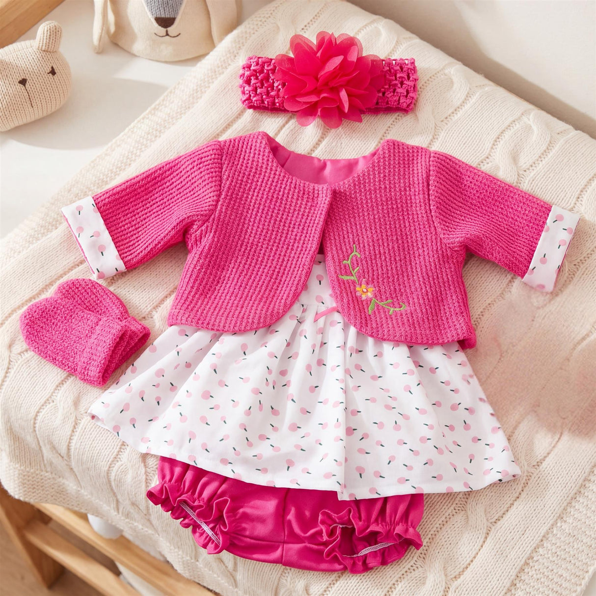 Ensemble featuring a hot pink cardigan, spotted white skirt, and coordinating pink ruffled bloomers.