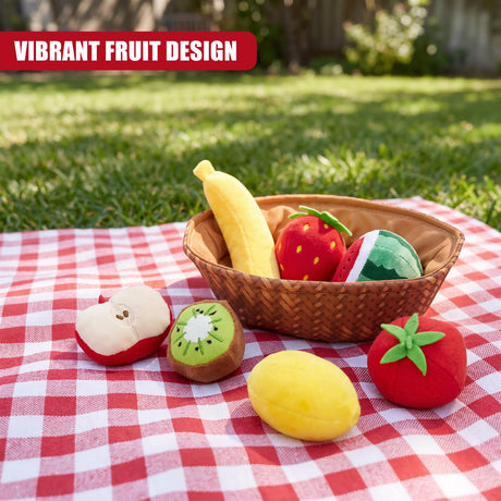 A red and white checkered picnic blanket displays a fabric fruit basket toy set containing plush apples, bananas