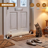 Cat-shaped draught excluder rests on the floor of a light door, positioned near a sitting tabby cat.