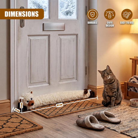 Cat-shaped draught excluder rests on the floor of a light door, positioned near a sitting tabby cat.