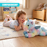 A pastel unicorn plush toy sits on the floor near a young girl.