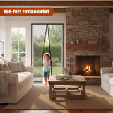 A living room with a child standing by a sliding glass door, holding a retractable screen door. The room features a stone fireplace, a wooden coffee table, and a comfortable sofa. The sliding door is open, with a garden visible outside. - UKBuyZone