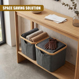 Two gray fabric storage bins rest on wood, containing rolled towels and a pair of brown gloves.