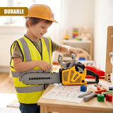 A young boy wearing a hard hat plays with a yellow plastic toy chainsaw on a wooden table.