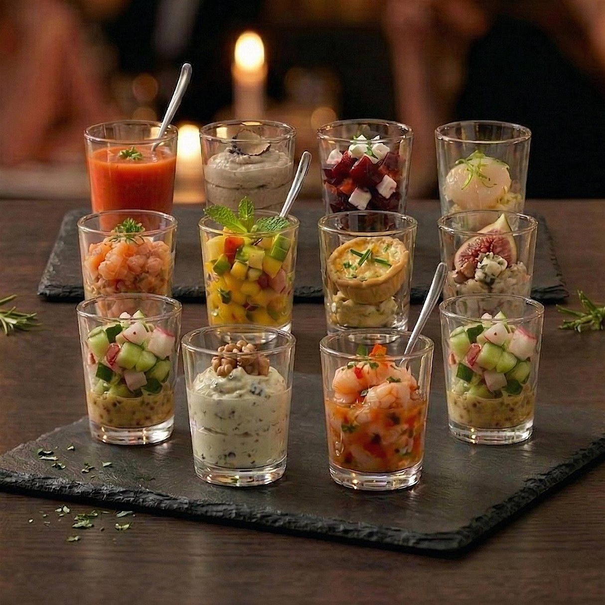 Assortment of twelve mini shot glasses holding colorful, individual dessert and appetizer portions.