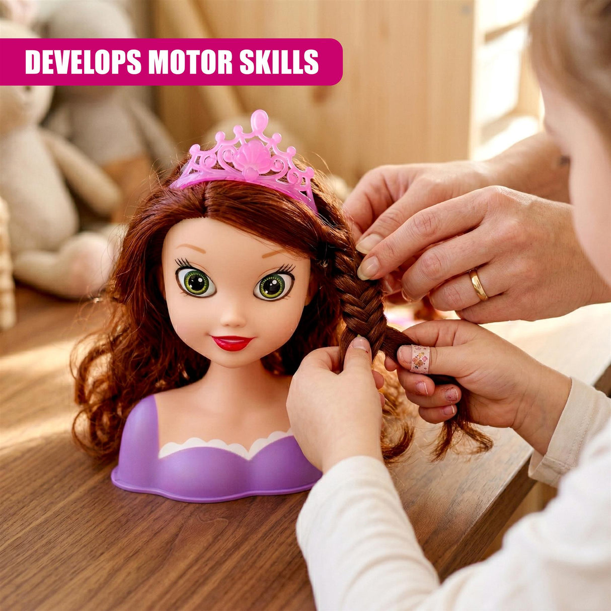 Hands braid the brown hair of a doll head wearing a pink crown and purple base.