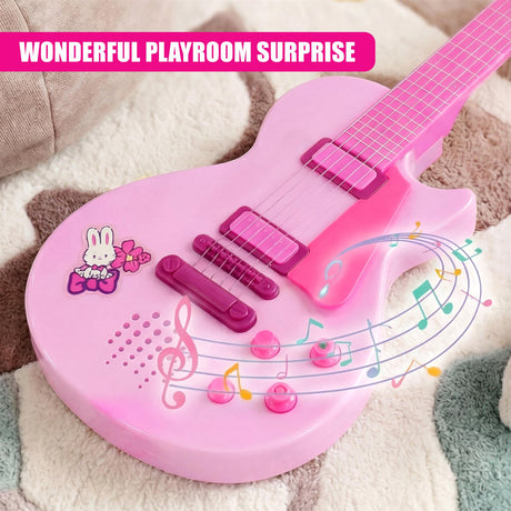 Pink toy guitar playset with stickers and accessories on a blanket.