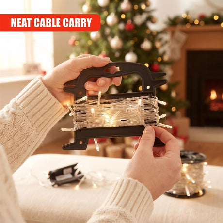 Hands hold a black GEEZY Christmas Light Reel Storage with fairy lights coiled inside, set against a blurred festive