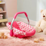 Pink baby play car seat with a heart pattern lining and curved carrying handle.