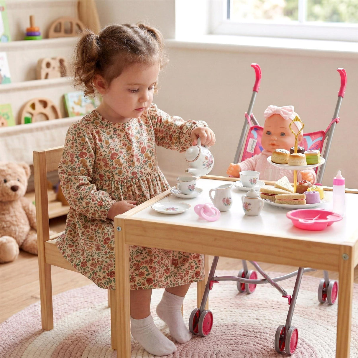 Little girl playing with a doll, stroller, and wooden tea and feeding accessory play set.