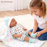 A spotted mint green doll outfit and matching booties are shown on a floral patterned blanket.