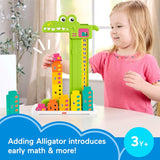 Little girl using the green alligator toy, which incorporates numbered blocks for counting and math.