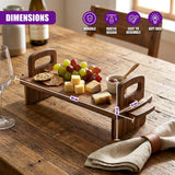 Wooden serving platter with curved handles, holding grapes, cheese cubes, crackers, and a small dipping bowl.