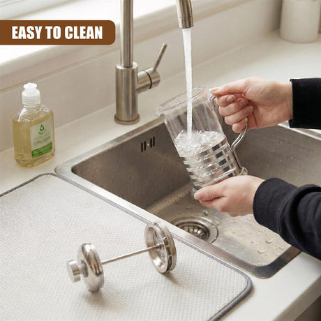 Hands wash a glass coffee pot with running water in a kitchen sink.