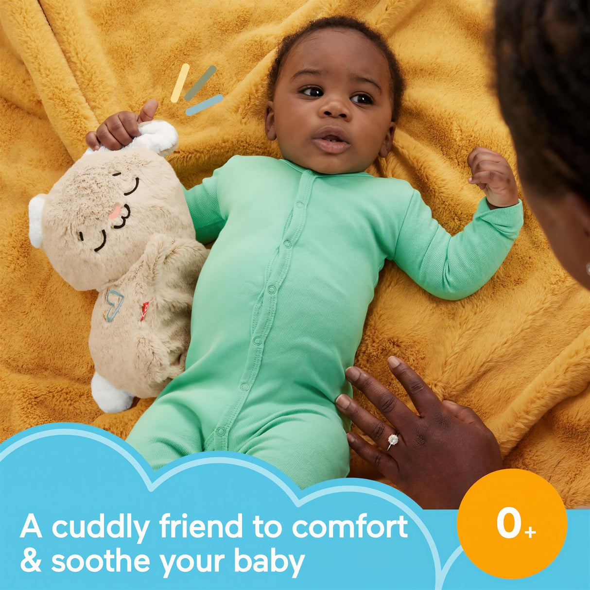 Infant wearing a light green sleeper near a plush bunny toy on a yellow blanket.