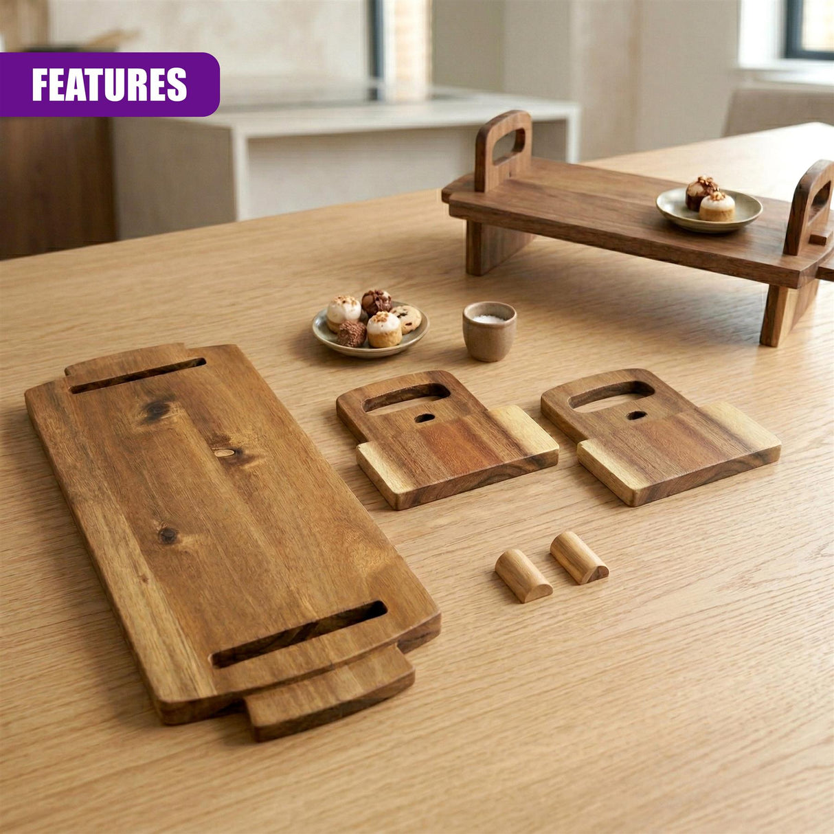 Multiple acacia wood serving boards, a platter, and small utensils displayed on a wooden table.