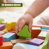 A hand selects a bright green wooden triangular block near other colorful wooden blocks.