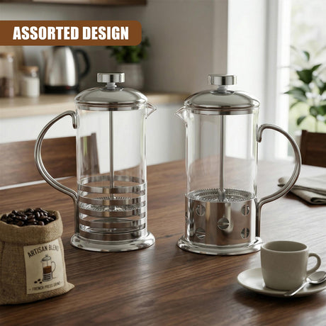 Pair of glass French press coffee makers with metallic components resting on a wooden surface.