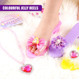 Play shoes with decorative bows, a beaded necklace, and a heart pendant on a white surface.