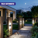 Illuminated acrylic wall lights mounted on vertical wooden posts defining a pathway through a garden.