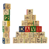 Stack of wooden blocks showing numbers, letters, and various themed pictograms like animals and objects.