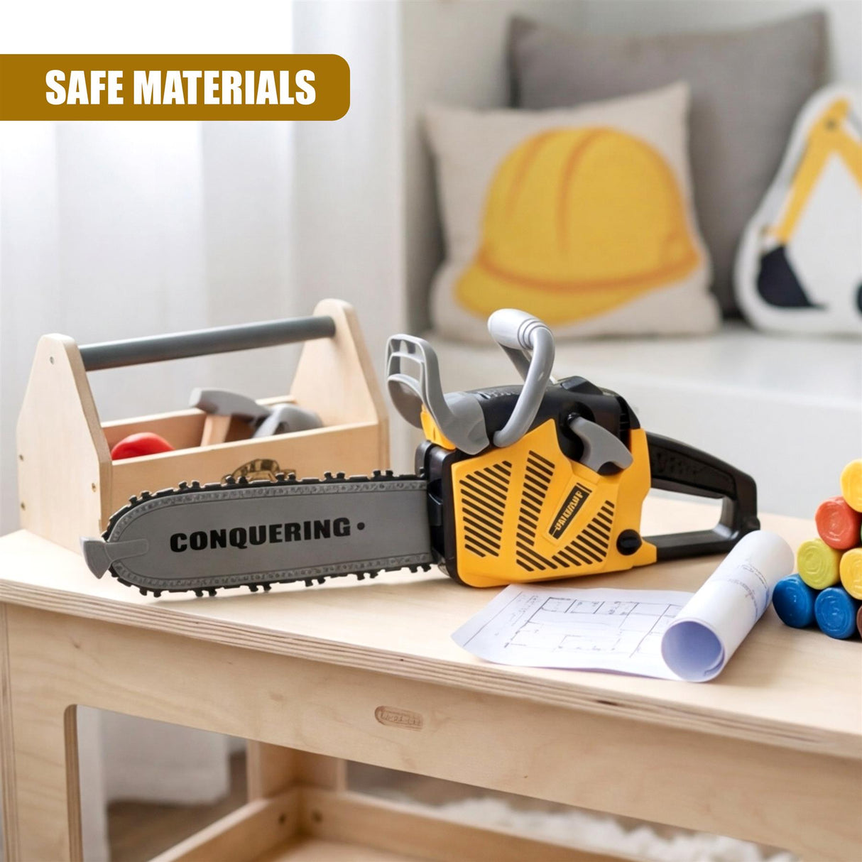 Yellow toy chainsaw and wooden toy bench rest on a table near rolled blueprints and blocks.