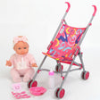 Pink doll sitting next to a matching stroller with feeding accessories and supplies.