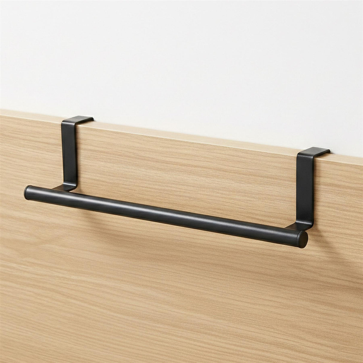 Black horizontal rail supported by brackets, mounted to a light wood paneling surface.