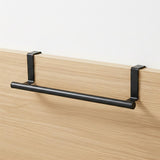 Black horizontal rail supported by brackets, mounted to a light wood paneling surface.