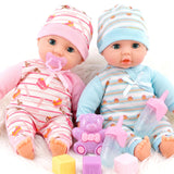 Two dolls in striped outfits sit with accessories, including a purple bear and blue and pink bottles.