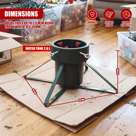 A green metal Christmas tree stand on a wooden floor, surrounded by storage boxes and cardboard packaging