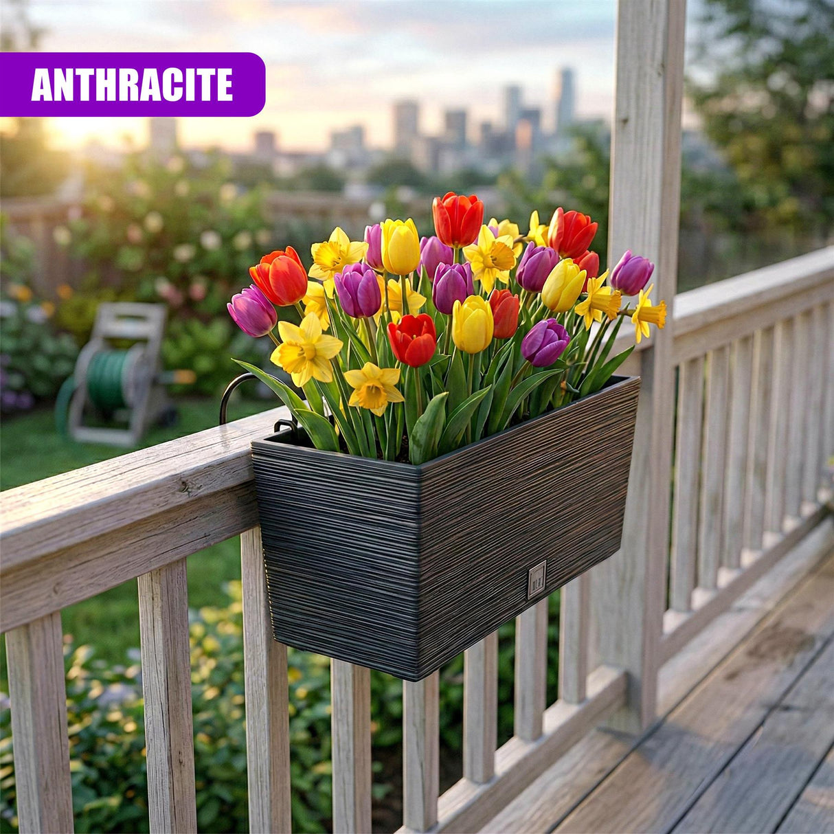 Dark anthracite rectangular planter holding bright spring tulips and yellow daffodils sits on a wood railing.