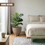 Ceramic brown pot with three legs holding a large potted indoor plant in a room.