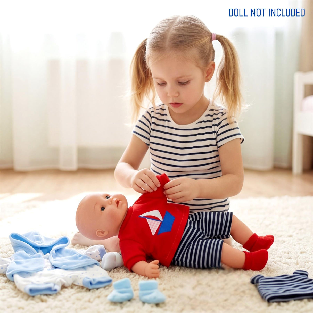 Doll surrounded by red, blue, and striped fabric outfits for children's play.